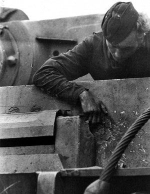 Немецкий танкист осматривает след от попадания советского снаряда на лобовой броне танка PzKpfw. V «Тигр». Курская дуга